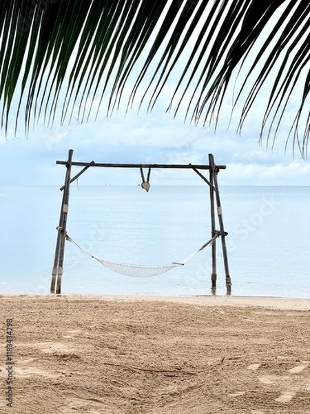 Fototapeta Wooden swing on the beach with the foreground of palm tree