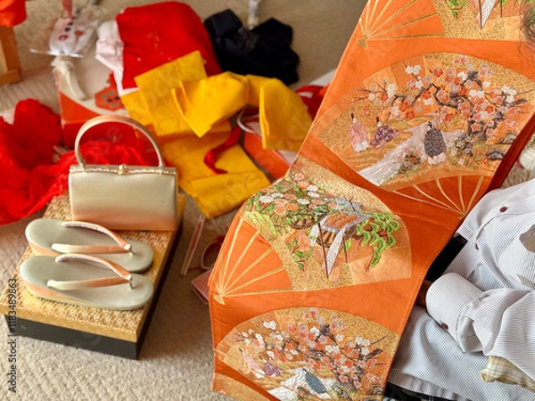 Fototapeta 着物の小物と帯を広げて見る女性