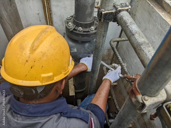 Obraz Construction Worker in a Hard Hat Fixing Pipes