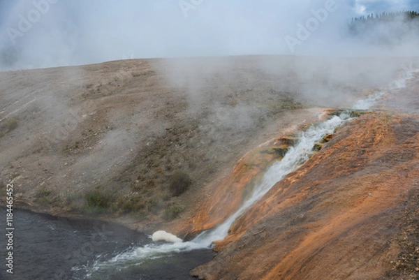 Fototapeta Excelsior Geyser Crater cascades scalding water forming a series of mini-waterfalls that tumble into the Firehole River