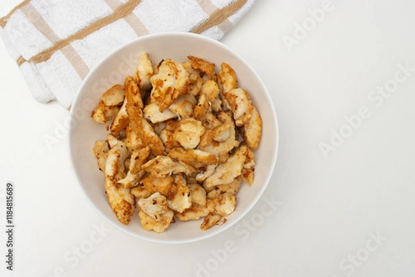 Fototapeta fried chicken pieces in white bowl. Dinner on white table. Close-up, copy space, top view