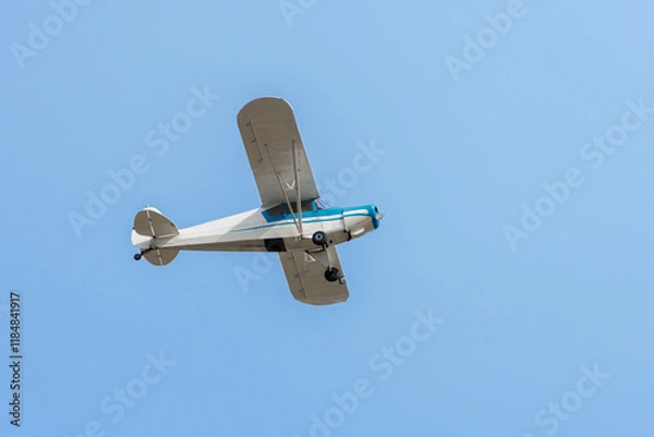 Obraz Small plane flying over the blue sky.