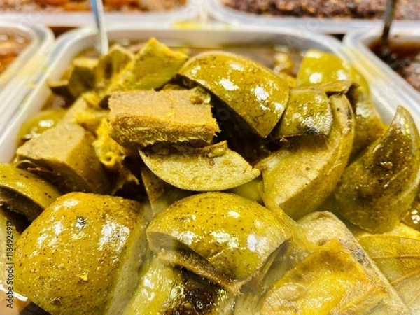 Fototapeta Closeup Mango Picklel. Homemade Mango Pickle or aam ka achar Kairi Loncha with Ingredients. Spicy avakaya raw mango pickle stored in a traditional jar. Selective focus.