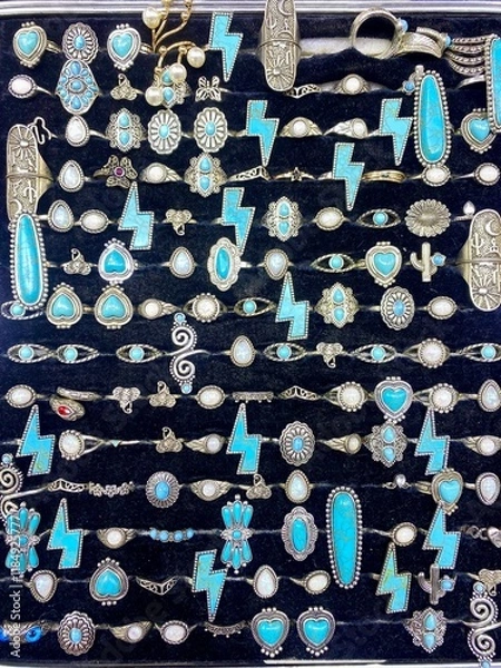 Fototapeta Experience the allure of opulence up close with a detailed view of gold necklaces, rings, and chains elegantly showcased in a beauty retail store window.