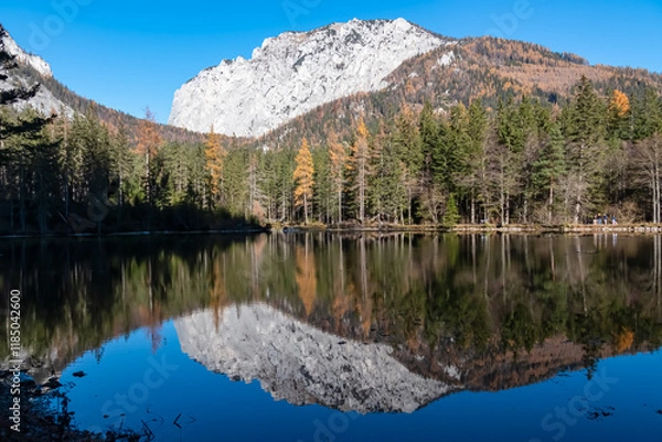Obraz Lake Kreuzteich surrounded by mountain peak Messnerin in Hochschwab Alps, Tragoess, Styria, Austria. Forest in vibrant autumn foliage. Crystal-clear water reflects majestic ridges. Mirror-like effect