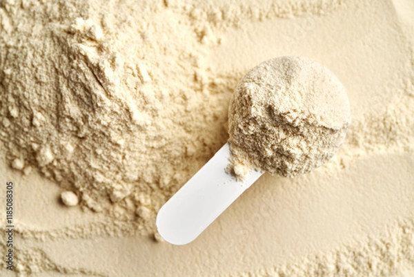 Fototapeta Whey protein powder in a measuring spoon, top view