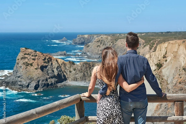 Fototapeta Beautiful couple standing on a viewpoint balcony and embracing e