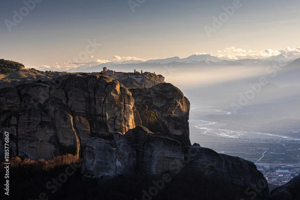 Fototapeta Travel to Meteora. The Monastery of Holy Trinity photographed in amazing sunset light with mountains in foreground. Travel to Orthodox iconic place of Meteora in Greece.