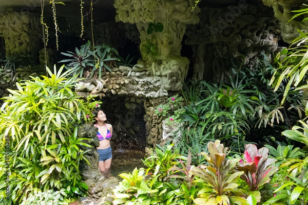 Obraz 緑豊かなリゾートプールにいる水着の日本人女性