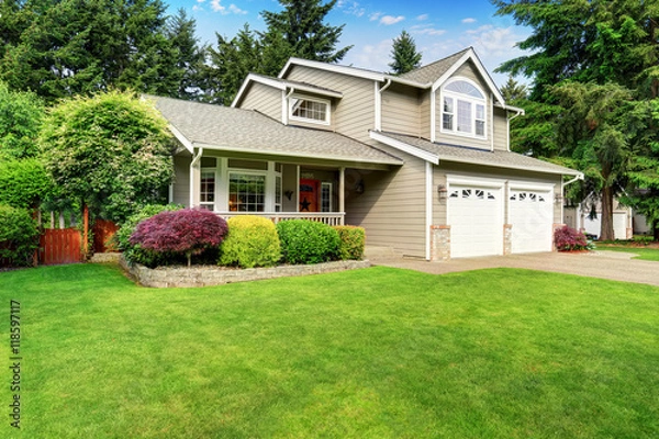 Obraz American house exterior with double garage and well kept lawn.