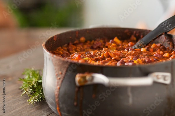 Obraz Organic Vegetarian Chili In Iron Pot Served With Rosemary On Dis