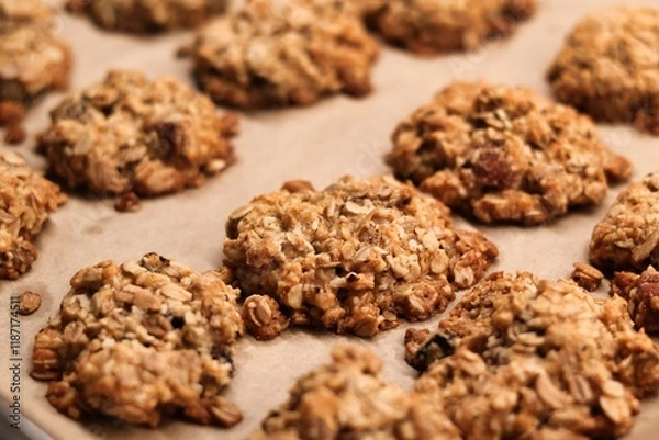 Obraz The process of preparing homemade oatmeal cookies - baked cookies placed on a baking tray lined with baking paper