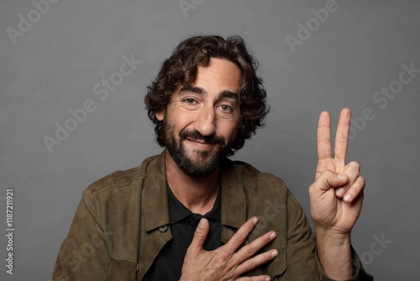 Fototapeta looking happy, confident and trustworthy, smiling and showing victory sign, with a positive attitude