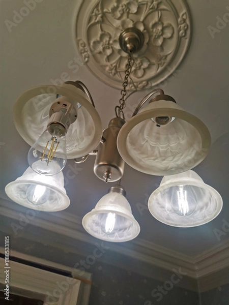 Fototapeta Elegant Ceiling Light Fixture with Decorative Medallion and Illuminated Glass Shades