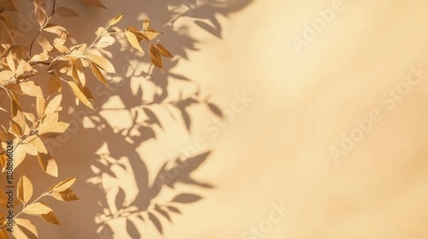 Fototapeta Dried leaves with a golden hue are silhouetted against a soft, warm-toned wall, casting intricate patterns of shadows. This natural display evokes a serene autumn atmosphere