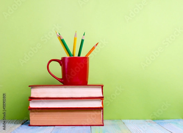Fototapeta Stack of hardback books, diary on wooden deck table and green background. Back to school. Copy Space. Education background