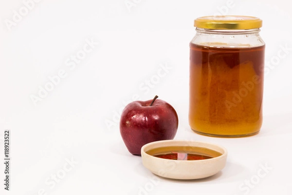 Fototapeta Red apple and jar of honey bowl of honey isolated on a white background