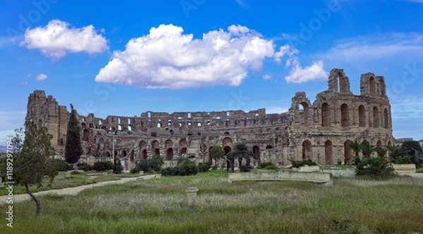 Fototapeta Amphitheater of El Jem in Tunisia with blue sky and clouds..
