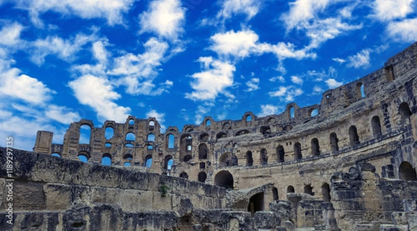 Fototapeta Amphitheater of El Jem in Tunisia with blue sky and clouds..