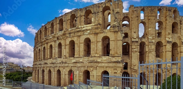 Fototapeta Amphitheater of El Jem in Tunisia with blue sky and clouds..
