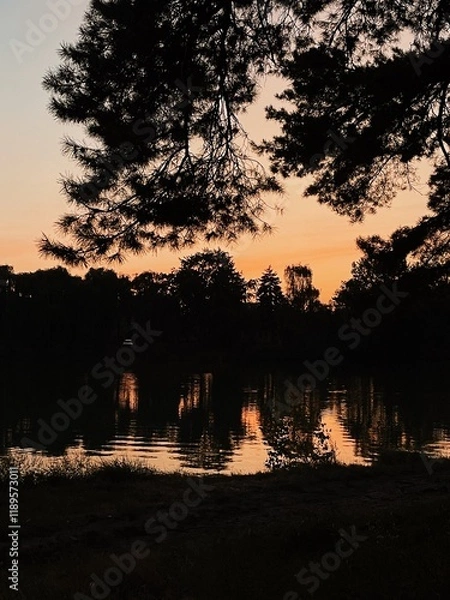 Fototapeta rest in nature outside the city with tents at night. Camping in the forest. Beautiful sunset sky with lights and reflection on the river