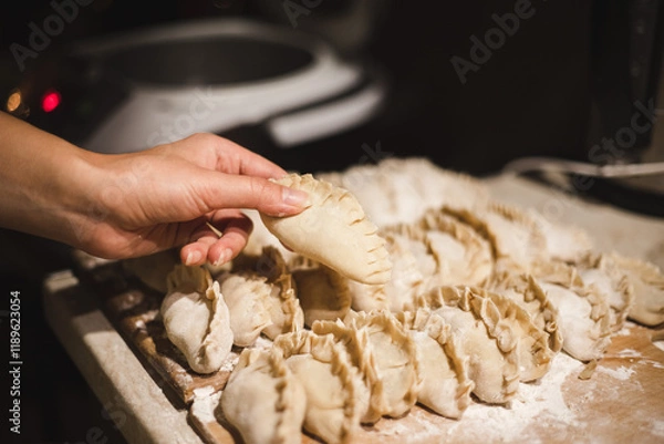 Obraz Making dumplings. Homemade dumplings. Raw dumplings. Cooking process. Dough product. Flour, dough, filling. Making by hand. Ukrainian dish. Vareniki with potatoes.