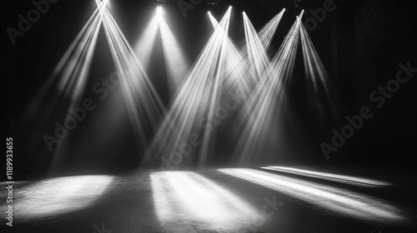 Fototapeta Black-and-white photography of an empty stage with spotlights shining down, creating beautiful light rays on the floor