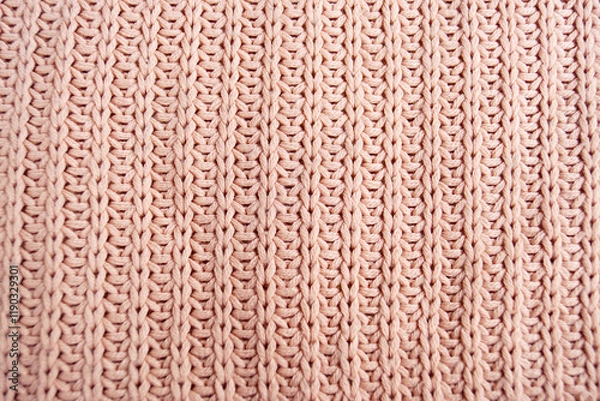 Fototapeta Texture of knitted fabric: a close-up photo of a pattern on a sweater made from soft pink yarn using the English rib stitch technique. An ancient decorative and applied art - knitting.