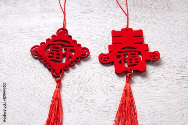 Fototapeta Red Chinese knots with traditional symbols and tassels, on a white wooden background.