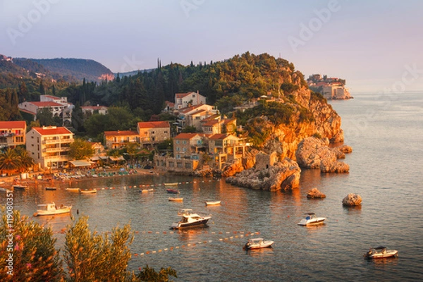Fototapeta View of the village Przno on a rocky beach in a picturesque bay at sunset. Adriatic Sea. Budva Riviera. Montenegro.