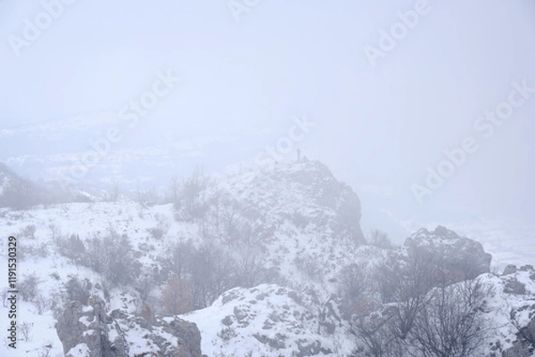 Obraz Distant mountain hiker on the top of the hill on a foggy day