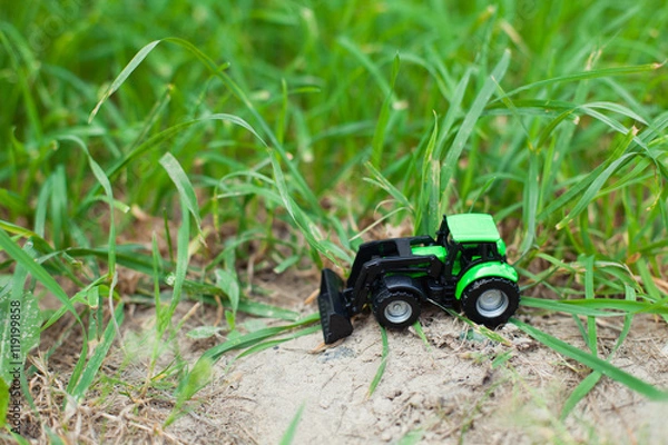 Obraz children's toy tractor on a green field