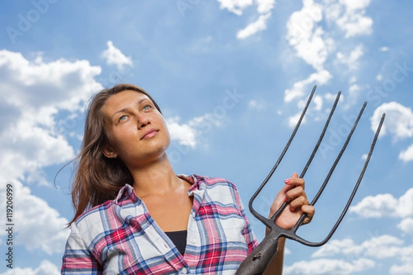 Obraz Happy female farmer with pitchfork in field