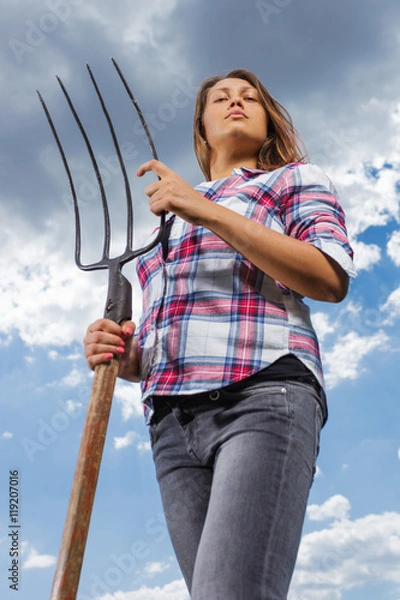 Obraz Happy female farmer with pitchfork in field