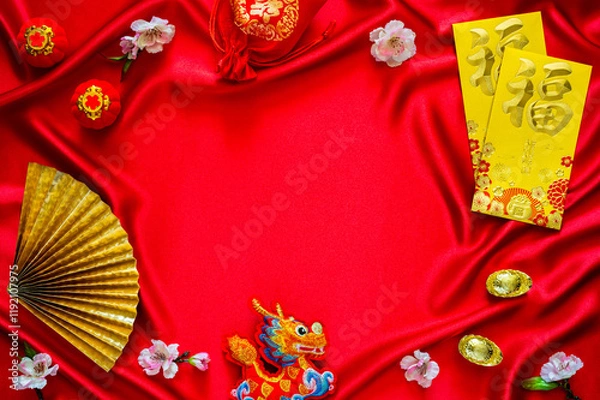 Fototapeta Chinese new year background with envelope packets or ang bao (word mean blessing), red bag and ingots (words mean wealth), hanging pendant dragon on red cloth background.