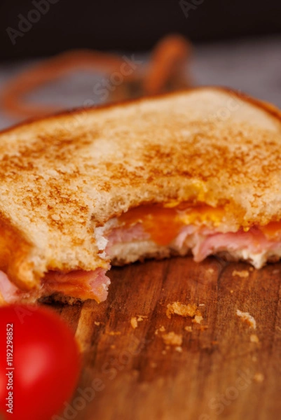 Fototapeta Flavorful Egg, Ham, and Cheese Sandwich with Cherry Tomatoes on a Gray Surface