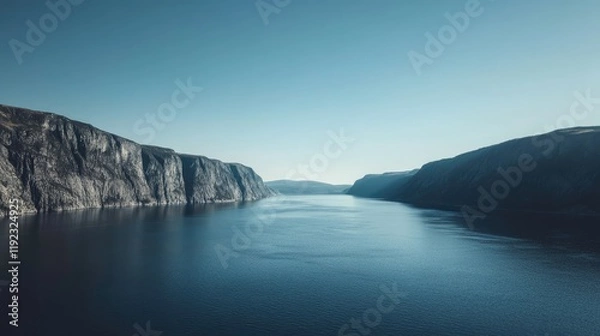 Fototapeta Scenic drive along a fjord, with steep cliffs and calm blue water on either side.
