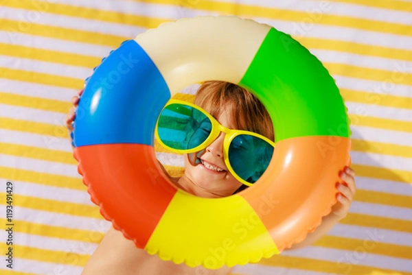 Fototapeta Top view portrait of happy child lying on beach towel on summer vacation