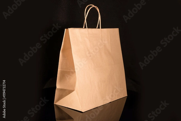 Obraz Recyclable craft paper bag for purchases, gifts and takeaway food mock up on black background. Environmentally friendly than single-use plastic bags