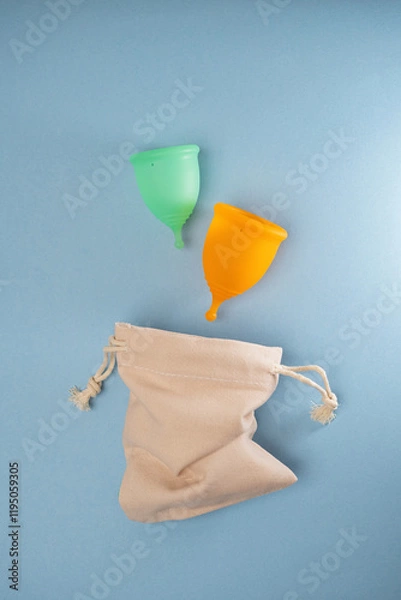 Obraz Two menstrual cups on a blue background. Flat image, top view.