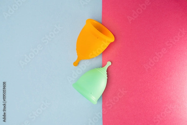 Obraz Two menstrual cups on a blue and pink background. Flat lay, top view.