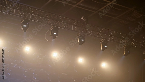 Fototapeta Bright yellow spotlights at show event. Light rays flashing in nightclub. Light projectors ceiling mount. Spot light on top. Illuminated technology in concert. Night party illumination