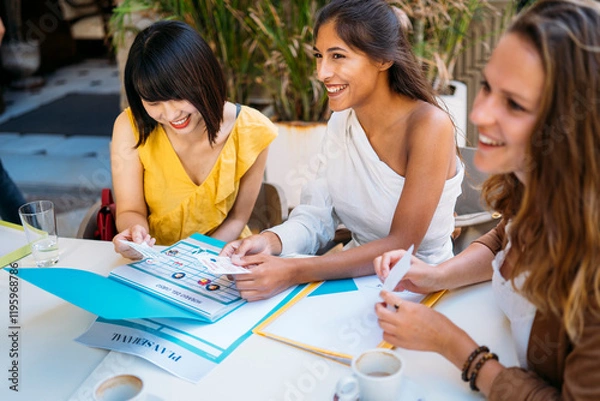 Obraz University exchange students organizing travel schedule together at cafe