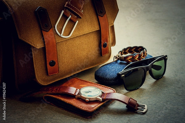 Fototapeta Męskie stroje codzienne z brązową torbą na aparat i akcesoriami na szarym tle grunge