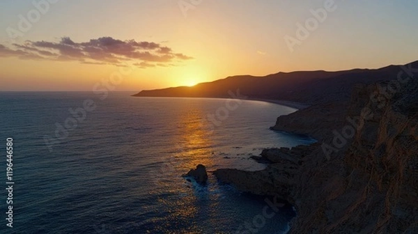 Fototapeta Sunset over a coastal landscape with cliffs and ocean waves.