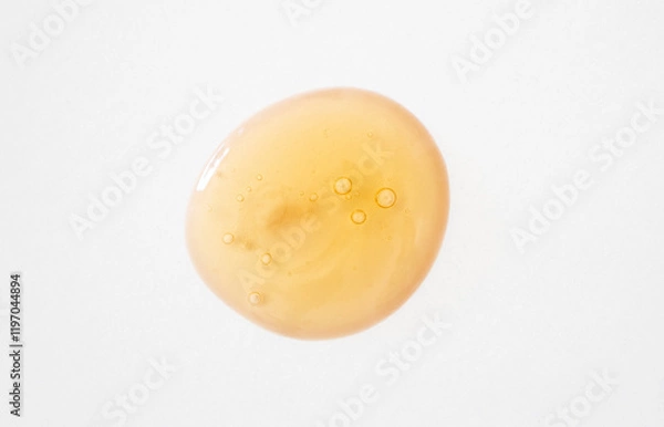 Fototapeta Serum with snail mucin and ginseng drop smear with bubbles close-up. Beauty product sample on white background.