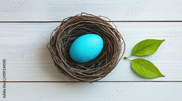 Fototapeta Simple Easter flat lay, white wooden background, a single sprig of green leaves, pastel-colored egg in a nest, clean aesthetic.