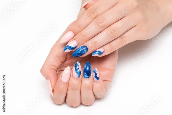 Fototapeta Blue smoky manicure with abstraction on long sharp nails close-up on a white background. Festive nail design