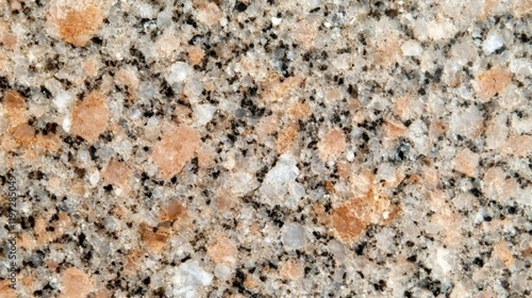 Fototapeta A textured surface of granite featuring a mix of beige, black, and white speckles, ideal for countertops and decorative purposes.