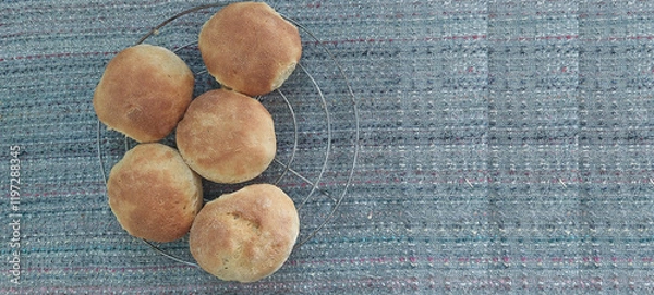 Fototapeta Homemade baked buns on a cooling rack on a gray background